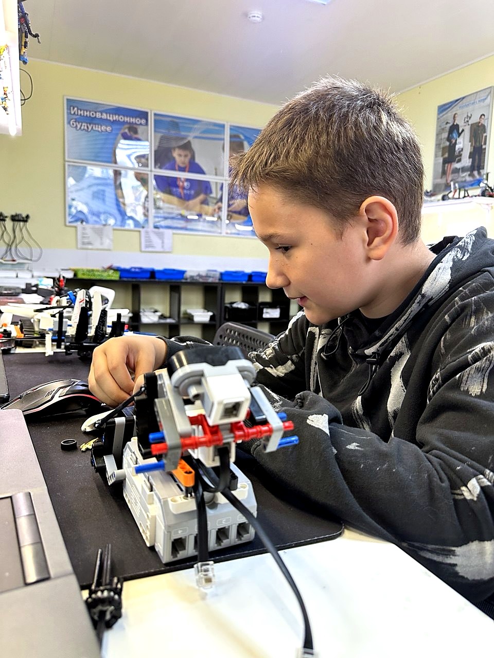 Мальчик собирает робота на LEGO EV3